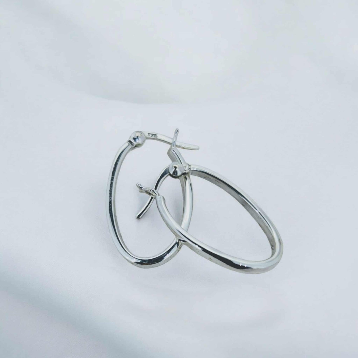 Narrow hoop sterling silver earrings designed with a secure French clip.