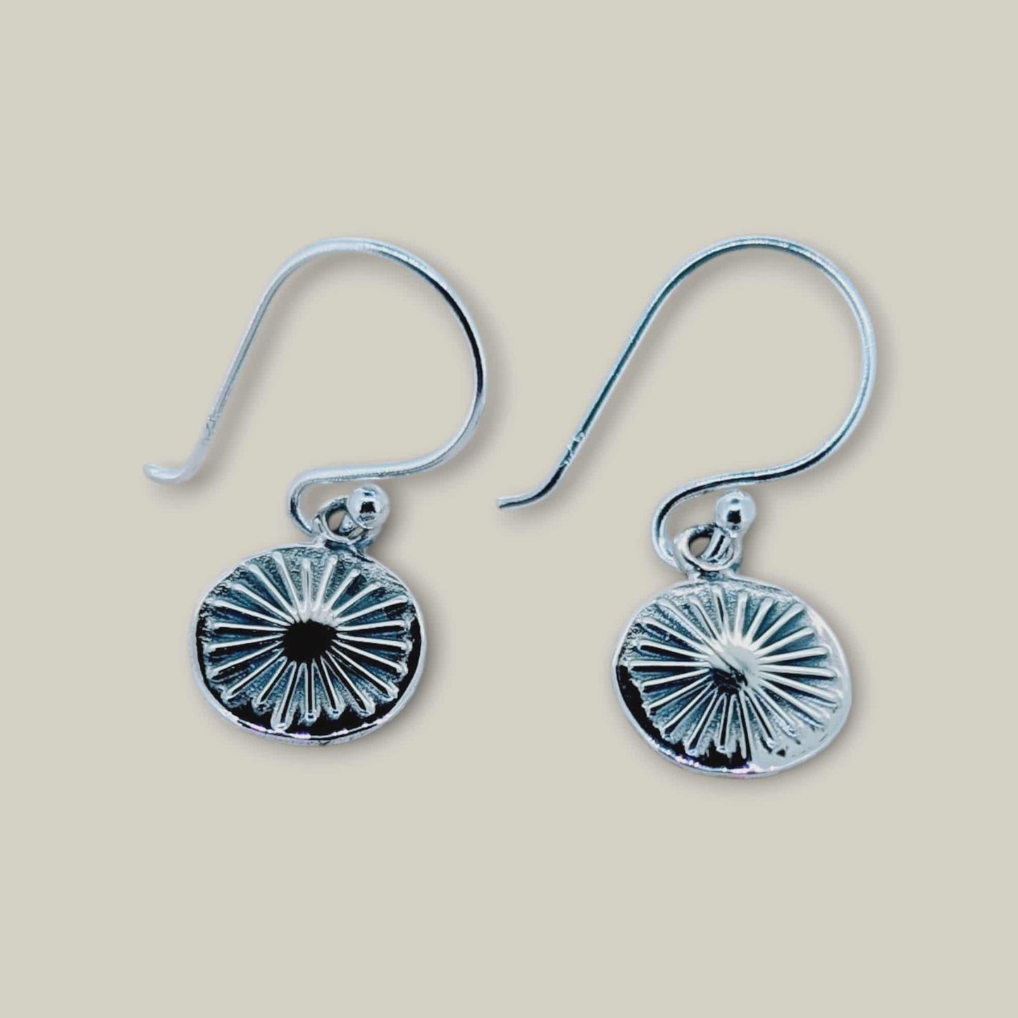 These silver earrings features a sun-inspired design, with fine, sculpted rays that fan outward to capture the brilliance of sunlight
