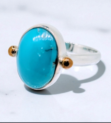 A striking turquoise cabochon is securely set in a deep-sided sterling silver bezel ring
