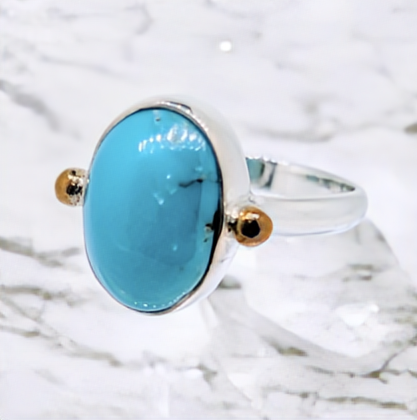A striking turquoise cabochon is securely set in a deep-sided sterling silver bezel ring